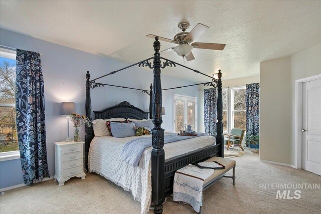 bedroom featuring multiple windows, ceiling fan, light carpet, and a textured ceiling