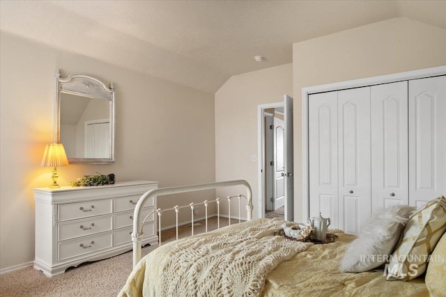 bedroom featuring light colored carpet, vaulted ceiling, a closet, and a textured ceiling