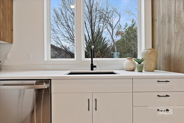 2007 S Makar Ln, Boise, ID 83706 - kitchen with stainless steel dishwasher, a sink, white cabinets, and light countertops