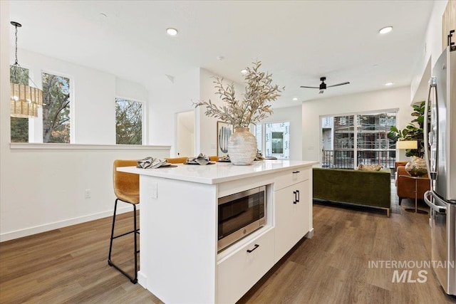 2007 S Makar Ln, Boise, ID 83706 - kitchen featuring appliances with stainless steel finishes, wood finished floors, white cabinetry, a center island, and recessed lighting