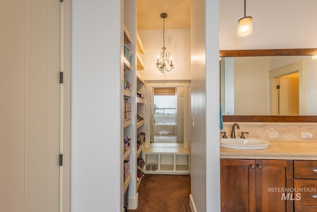 bathroom featuring tasteful backsplash, vanity, and an inviting chandelier