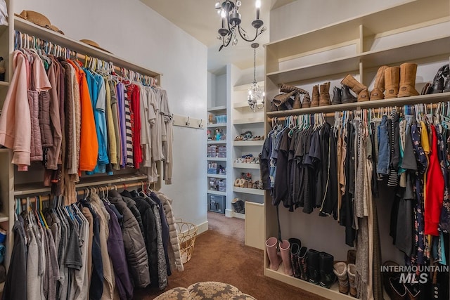 walk in closet featuring carpet floors and a chandelier