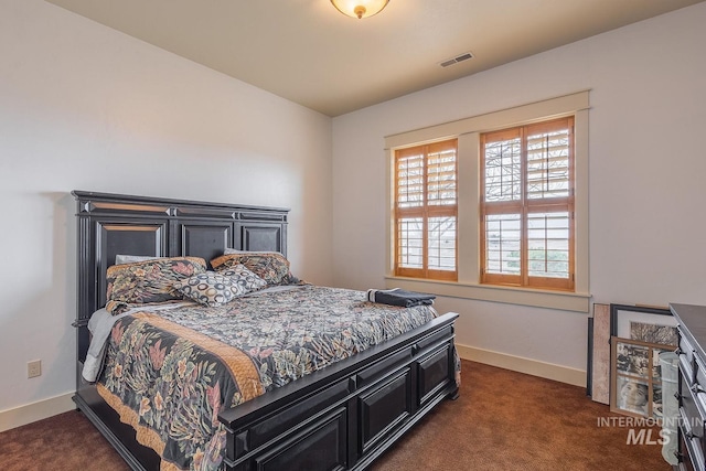 bedroom featuring baseboards, visible vents, and dark colored carpet