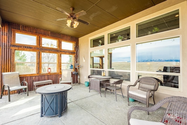 sunroom with a wealth of natural light, wood ceiling, and ceiling fan