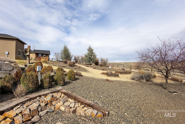 view of yard featuring a rural view and fence