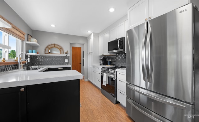2906 W Kathryn St, Boise, ID 83705 - kitchen featuring stainless steel appliances, a sink, light wood-style floors, tasteful backsplash, and white cabinets