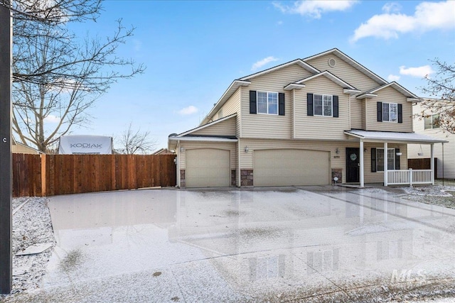 view of property with covered porch and a garage