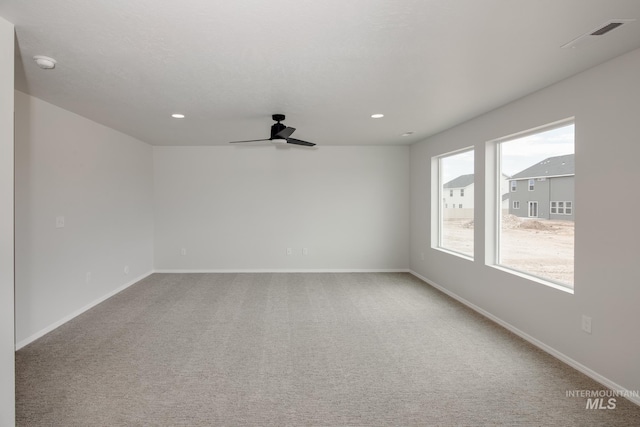 carpeted spare room with ceiling fan