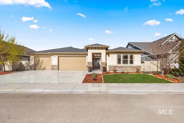 prairie-style house with concrete driveway, stucco siding, fence, an attached garage, and stone siding