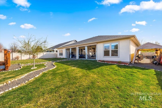 back of house with a patio area, stucco siding, fence, a carport, and a lawn