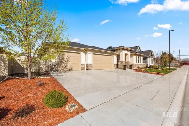 prairie-style house featuring stone siding, concrete driveway, stucco siding, and an attached garage