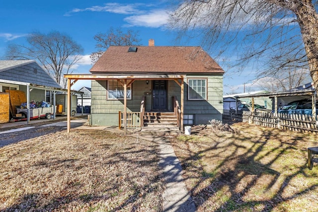 view of front of property featuring covered porch, roof with shingles, fence, and a chimney