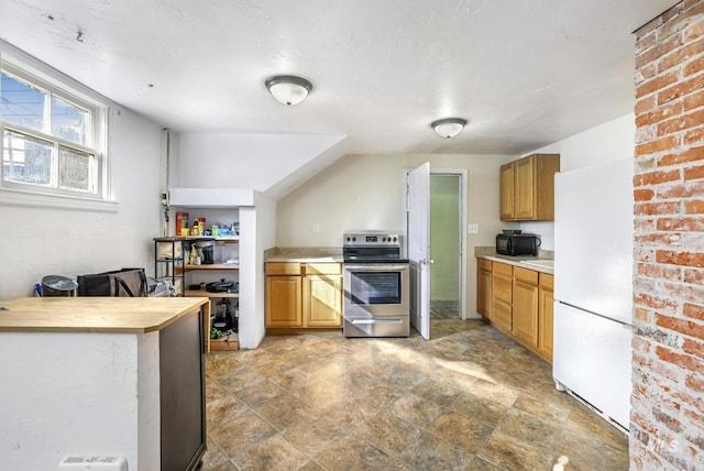 kitchen featuring black microwave, light countertops, stainless steel electric range, freestanding refrigerator, and brown cabinetry