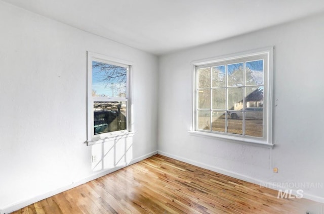 unfurnished room featuring baseboards and wood finished floors