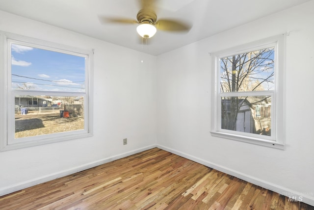 unfurnished room featuring a ceiling fan, baseboards, and wood finished floors