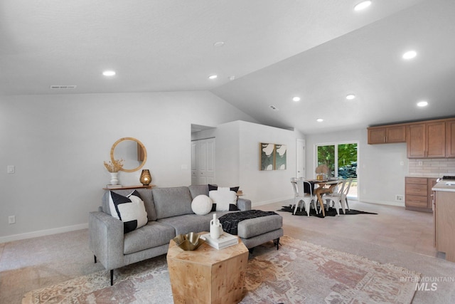 living room with lofted ceiling and light colored carpet