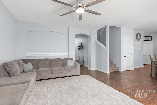 6495 S Mistyglen Ave, Boise, ID 83709 - living room with ceiling fan, arched walkways, stairway, wood finished floors, and baseboards