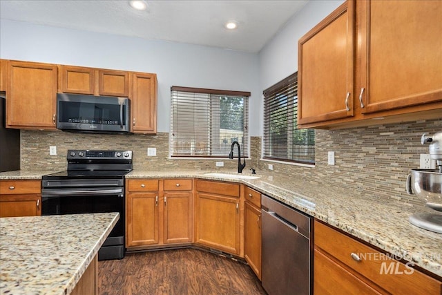 6495 S Mistyglen Ave, Boise, ID 83709 - kitchen featuring appliances with stainless steel finishes, a sink, dark wood-style floors, brown cabinets, and recessed lighting