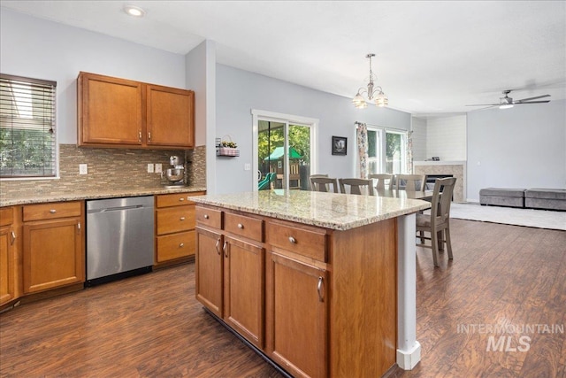 6495 S Mistyglen Ave, Boise, ID 83709 - kitchen featuring stainless steel dishwasher, backsplash, dark wood finished floors, and brown cabinetry