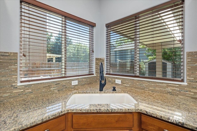 6495 S Mistyglen Ave, Boise, ID 83709 - kitchen view of a sink, backsplash, and brown cabinetry