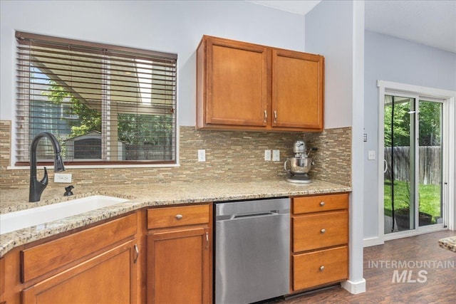 6495 S Mistyglen Ave, Boise, ID 83709 - kitchen featuring stainless steel dishwasher, a sink, decorative backsplash, dark wood-style flooring, and brown cabinetry