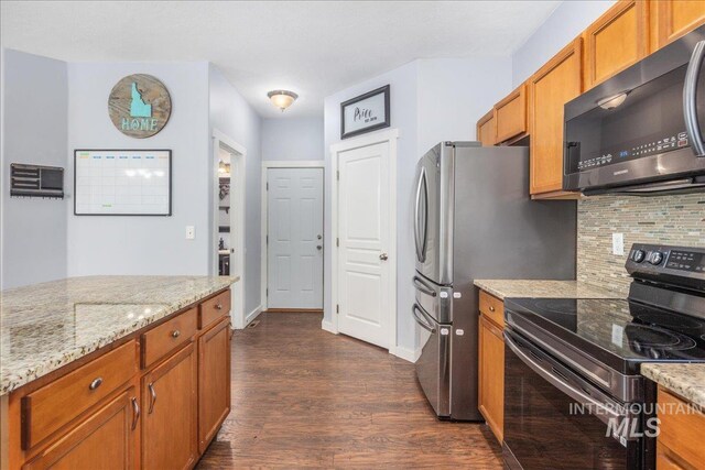 6495 S Mistyglen Ave, Boise, ID 83709 - kitchen with black electric range, dark wood-style floors, decorative backsplash, brown cabinetry, and light stone countertops
