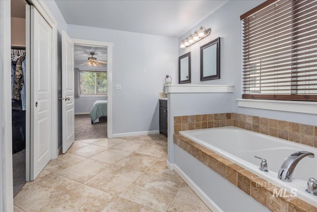 6495 S Mistyglen Ave, Boise, ID 83709 - ensuite bathroom with a garden tub, vanity, a spacious closet, ceiling fan, and baseboards