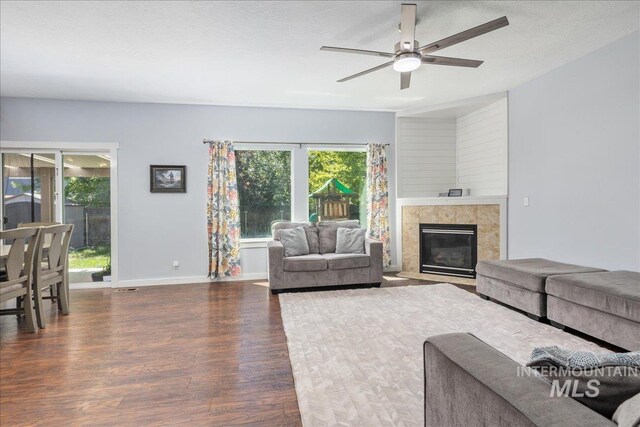 6495 S Mistyglen Ave, Boise, ID 83709 - living area with wood finished floors, a ceiling fan, a tiled fireplace, and baseboards