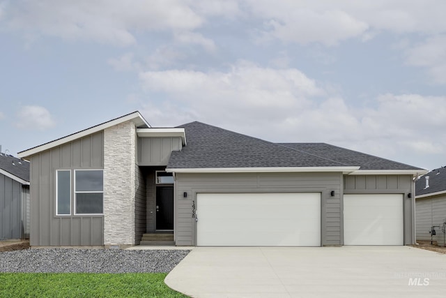 view of front of property featuring driveway, an attached garage, a shingled roof, and board and batten siding