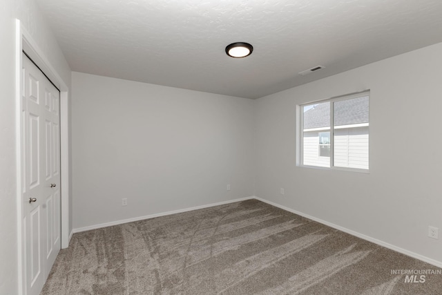 unfurnished bedroom with carpet flooring, a closet, visible vents, and baseboards