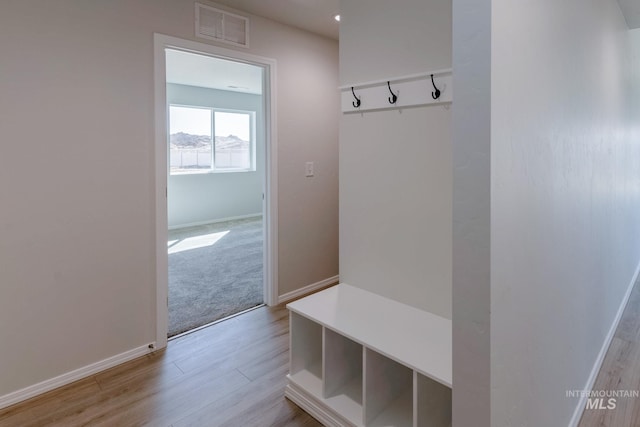 mudroom with baseboards, light wood finished floors, and visible vents