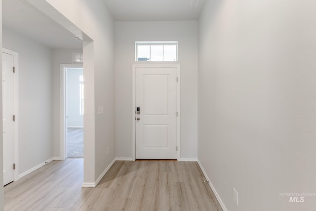 foyer with baseboards and light wood-type flooring