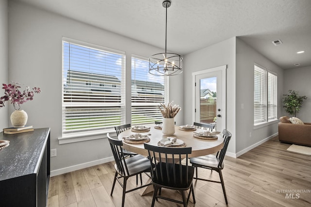 10061 W La Jolla Dr, Boise, ID 83709 - dining room featuring a chandelier, light wood finished floors, and a textured ceiling