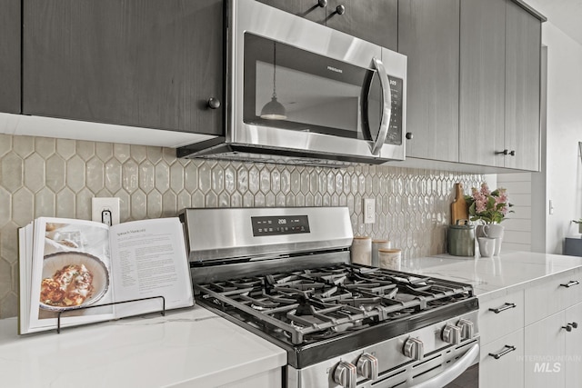 10061 W La Jolla Dr, Boise, ID 83709 - kitchen with stainless steel appliances, light stone countertops, and backsplash