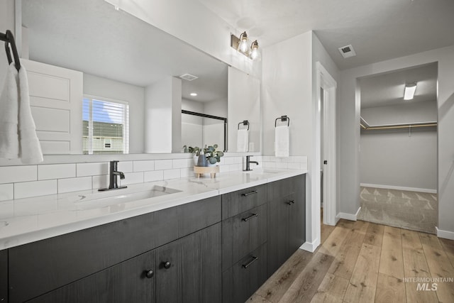 10061 W La Jolla Dr, Boise, ID 83709 - full bath with wood finished floors, double vanity, decorative backsplash, and a spacious closet