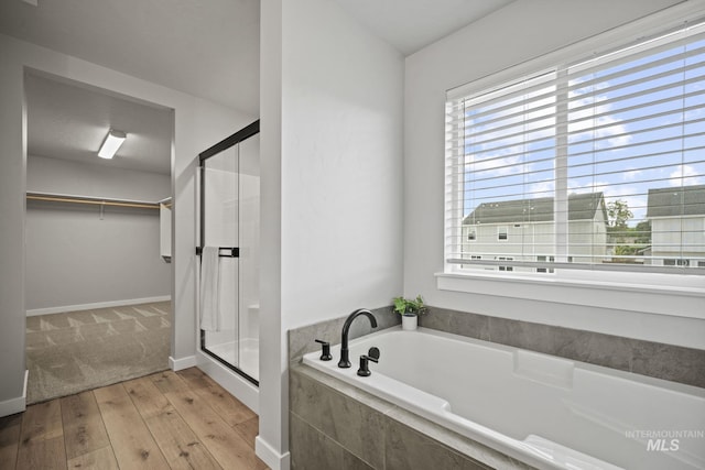 10061 W La Jolla Dr, Boise, ID 83709 - full bathroom with a garden tub, a stall shower, a spacious closet, and hardwood / wood-style floors