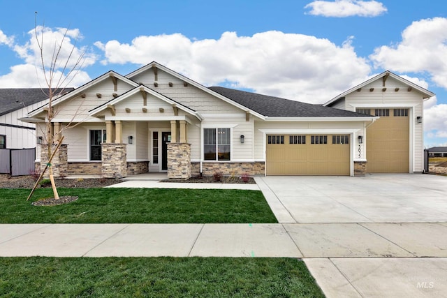 view of front facade with a front lawn, an attached garage, stone siding, and driveway