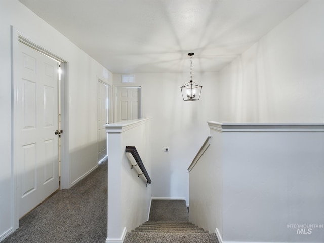 staircase with carpet and a notable chandelier