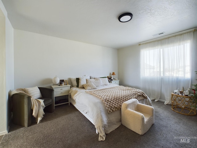 carpeted bedroom featuring a textured ceiling