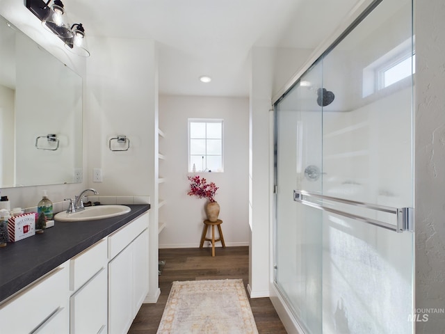 bathroom featuring wood-type flooring, vanity, and a shower with door