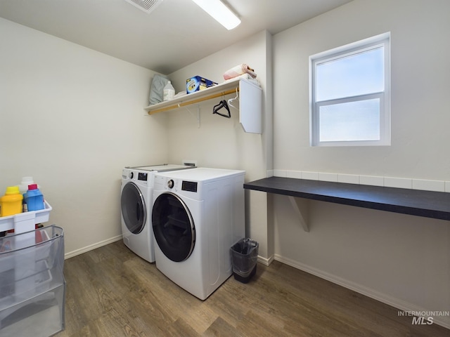 laundry area with dark hardwood / wood-style flooring and independent washer and dryer