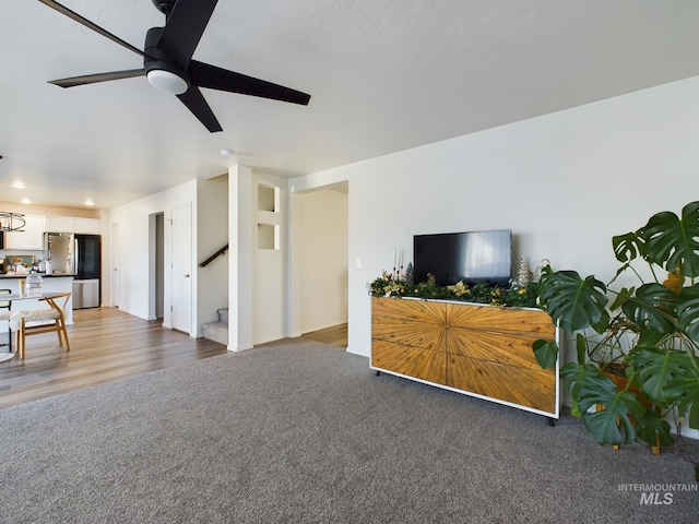 living room with ceiling fan and dark hardwood / wood-style flooring