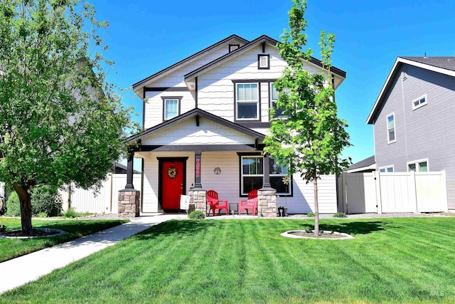 view of front of house with a porch, a gate, a front lawn, and fence