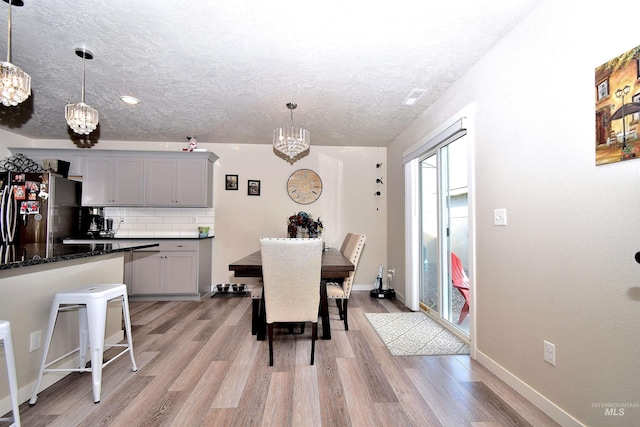 dining space featuring an inviting chandelier, light wood finished floors, and plenty of natural light