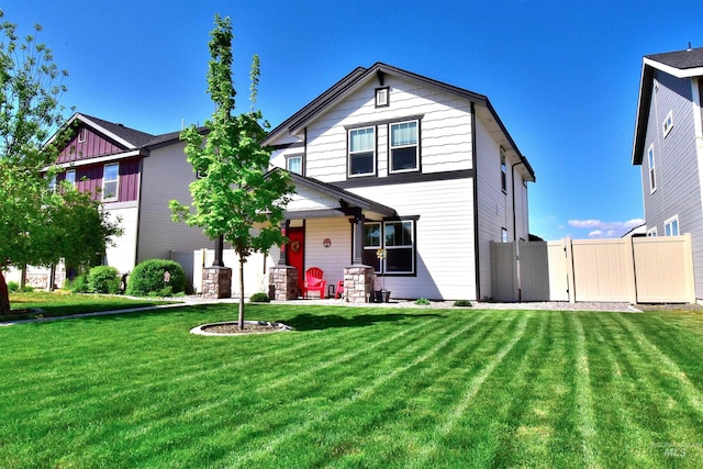 traditional home with fence and a front lawn