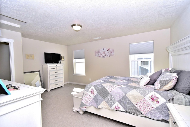 carpeted bedroom featuring baseboards and a textured ceiling