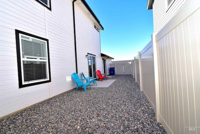 view of property exterior with a patio and a fenced backyard