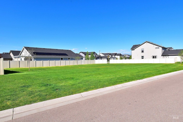 view of yard featuring fence and a residential view
