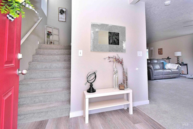 staircase featuring baseboards and wood finished floors