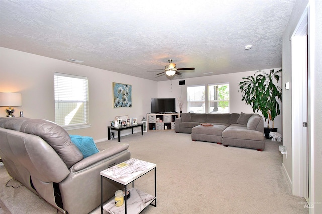 living area featuring visible vents, baseboards, ceiling fan, a textured ceiling, and carpet flooring